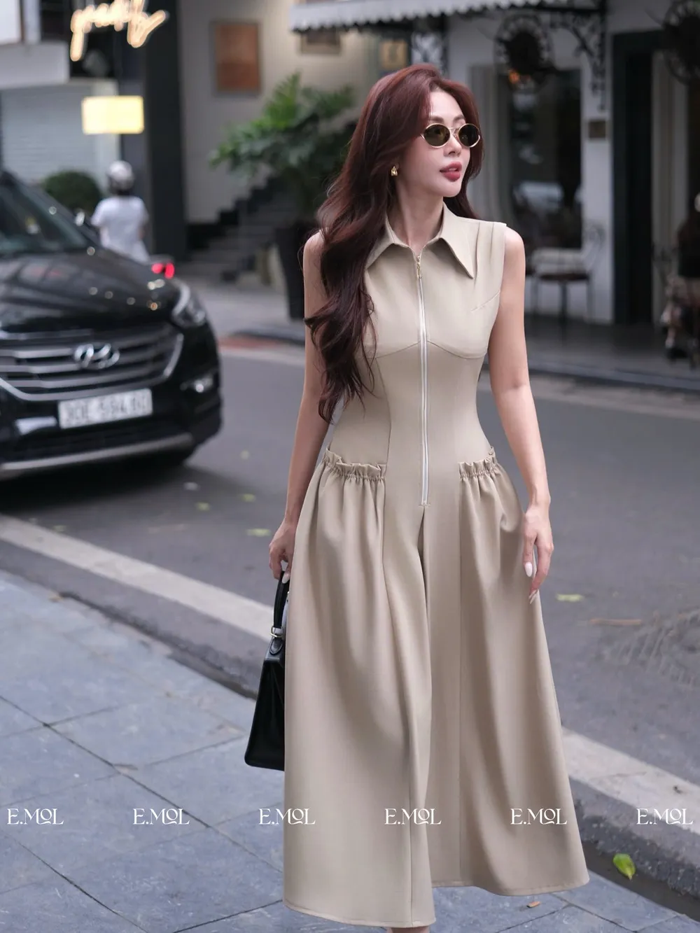 The Dress Is Designed with A Sleeveless Shirt Collar and A Stylized Front Pocket — original E.MOL photograph 1
